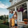 Happy family in front of their new home representing homeownership opportunities for individuals with bad credit